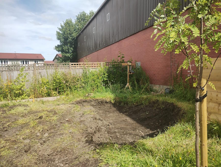 click to see larger image digging the pond in the community garden