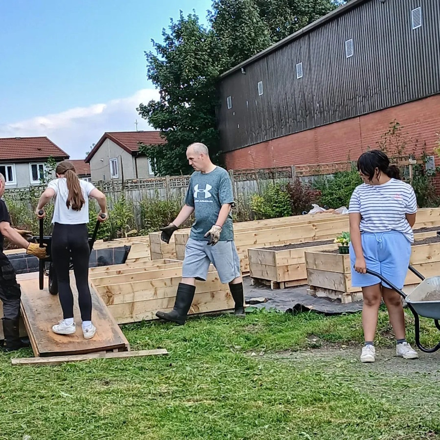 click to see larger image many hands make light work in the community garden