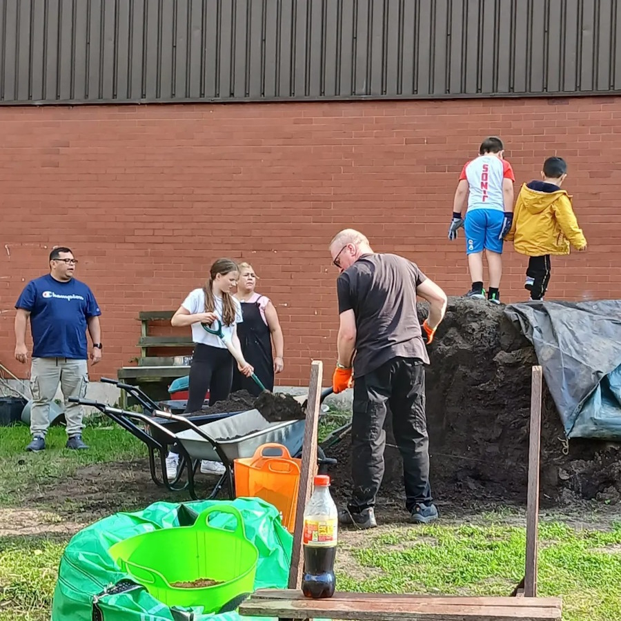 click to see larger image many hands make light work in the community garden